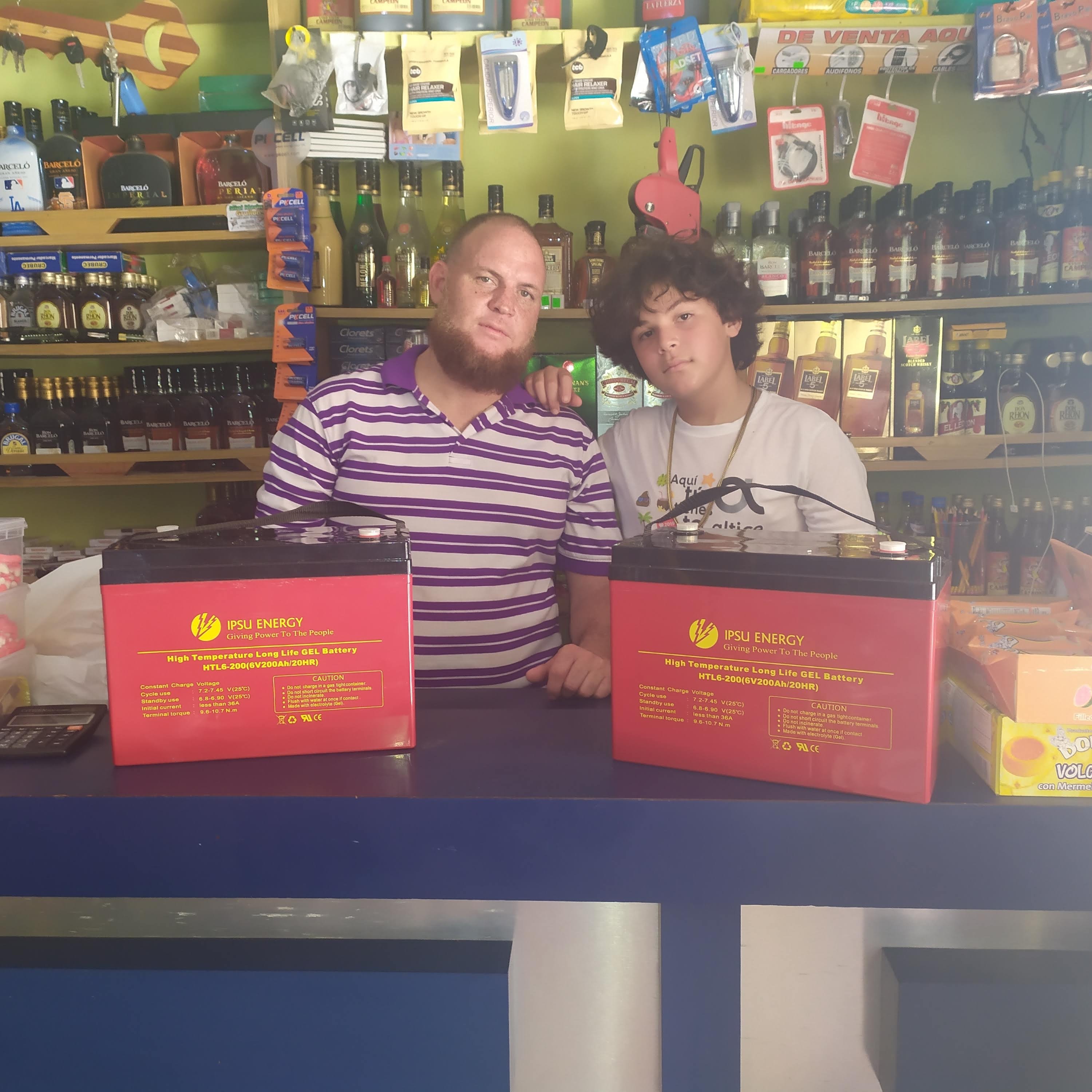 Customers with IPSU Energy HTL6-200 Deep Cycle batteries at retail store in the Dominican Republic