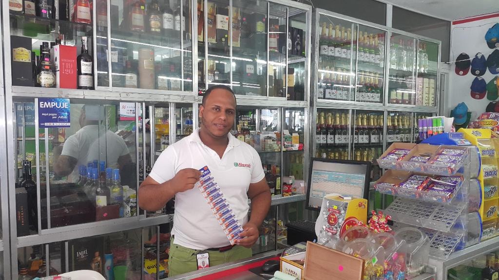 Almanzar staff member holding PKCELL batteries at counter
