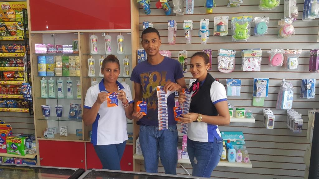 Three store staff members holding PKCELL Ultra Alkaline batteries
